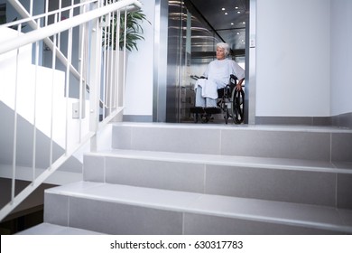 Disabled senior patient on wheelchair in lift at hospital