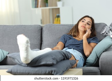 Disabled Serious Woman Talking On Phone Sitting On A Couch In The Living Room At Home