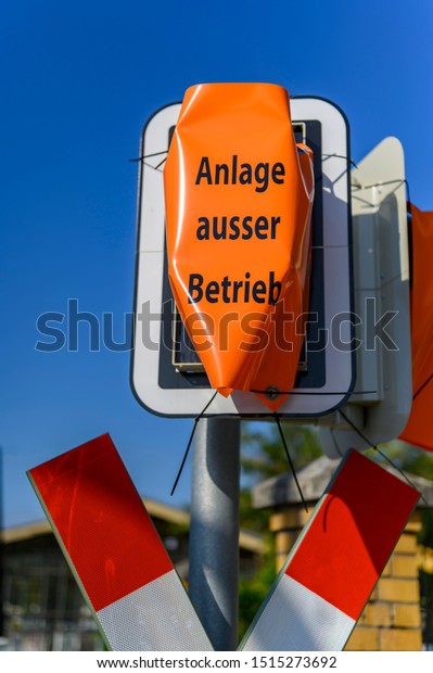 Disabled signal system at a railroad crossing of\
the new railway line Berlin-Dresden. This is located in southern\
Berlin, Germany, in the district Lichtenrade. Text: German for\
\