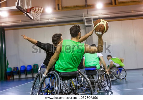 disabled sport men in action while playing indoor\
basketball at a basketball\
court