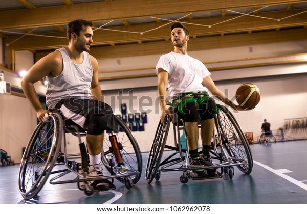 disabled sport men in action while playing indoor\
basketball at a basketball\
court