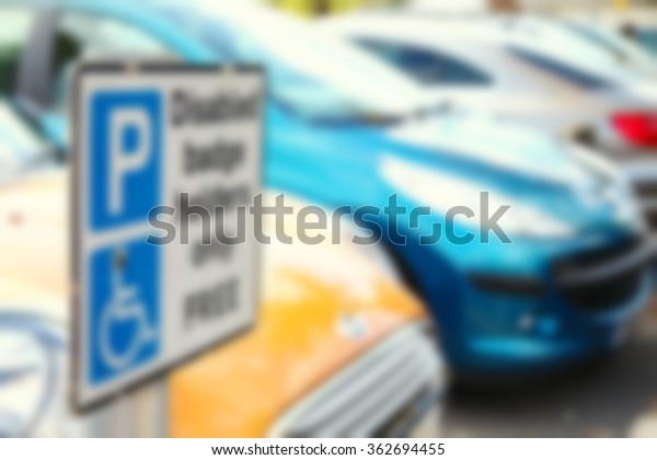 The disabled\
traffic signage at the car park background represent the sign and\
symbol concept related\
idea.