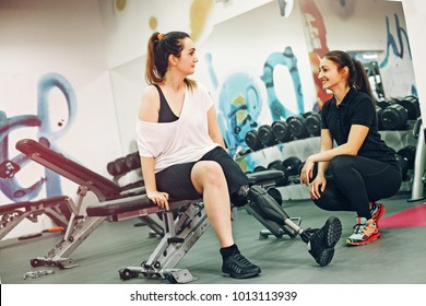 Disabled woman exercising with personal trainer in the gym 