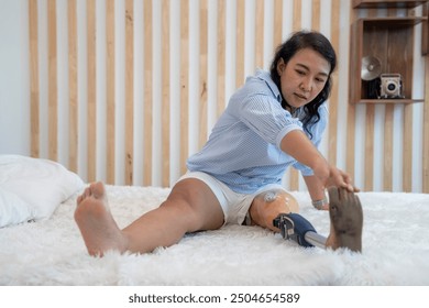 A disabled woman with one prosthetic leg is happily sitting on a bed. - Powered by Shutterstock