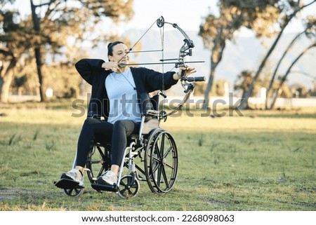 Disabled woman, outdoor archery in wheelchair and challenge with active sports lifestyle in Canada. Person with disability in a park, fitness activity to exercise arms and aim arrow for hobby