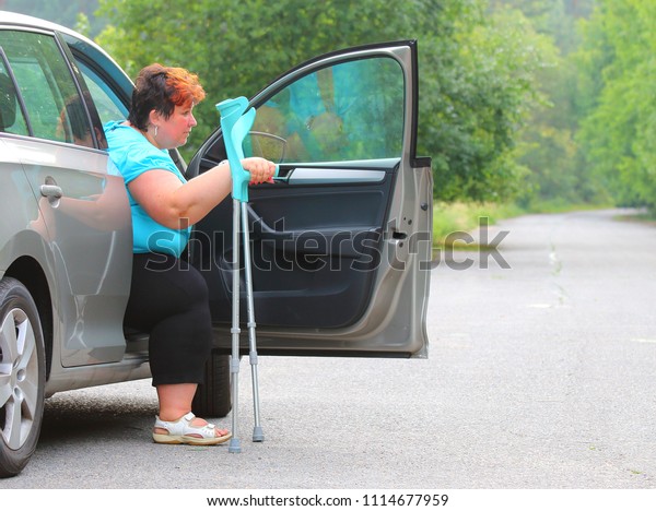Disabled woman upgoing from a car.\
Transportation and travel for handicapped people.\
a11y
