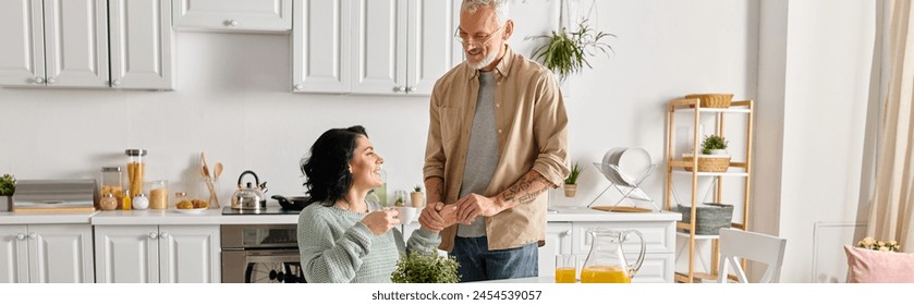 A disabled woman in a wheelchair and her husband sharing a moment in their kitchen at home. - Powered by Shutterstock