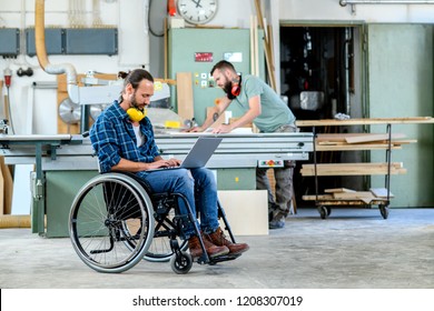 disabled worker in wheelchair in a carpenter's workshop with his colleague - Powered by Shutterstock