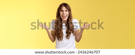 Disappointed angry furious woman shrugging hands sideways dismay frustration shouting complaining feel outraged pissed arguing scream intense rage stand yellow background quarrel.
