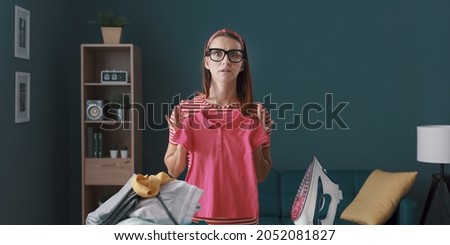 Disappointed housewife having laundry problems, she is holding a shrunken t-shirt