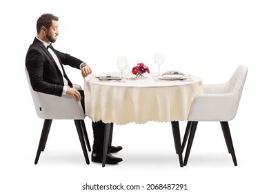 Disappointed Man Sitting Alone At A Restaurant Table And Checking Time Isolated On White Background