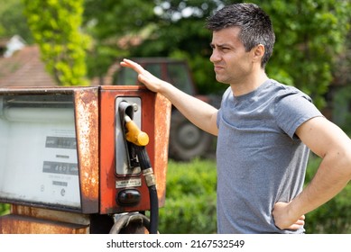 Disappointed Man Standing Beside Old Rusty Gasoline Pump Out Of Service