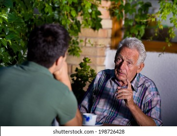 Disappointed old man pointing forefinger in young man