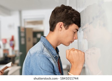 Disappointed University Student Leaning On Whiteboard With Closed Eyes. Tired High School Guy Feeling Failure In Classroom. Side View Of Sad Young College Student Trying To Solve Math Problem.