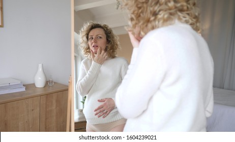 Disappointed And Upset Pregnant Woman Looking In Mirror At Her Problem Skin. - Shutterstock ID 1604239021