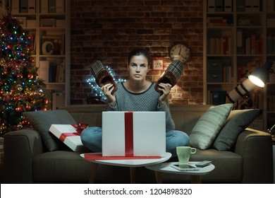 Disappointed Woman Receiving A Dissatisfying Christmas Gift: She Is Holding A Pair Of Ugly Slippers