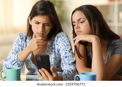 Disappointed women watching media on phone at home - Shutterstock ID 2359706771