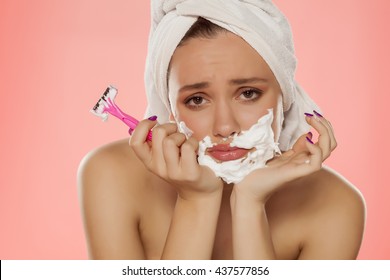 Disappointed Young Woman With Foam On The Face And A Razor In Her Hand