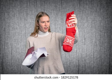 A Disappointed Young Woman Holds Her Gift Up