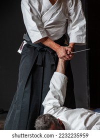Desarmar a un oponente armado con cuchillos. Maestros superiores del aikido del cinturón negro durante una sesión de entrenamiento.