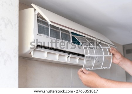 Disassembled AC Unit During Filter Cleaning Process. A man repairing an air conditioner. A male air conditioner technician or air conditioning installation. technician is about to repair air conditioning in homes and buildings.