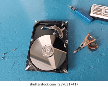 Disassembled computer hard drive on a blue table