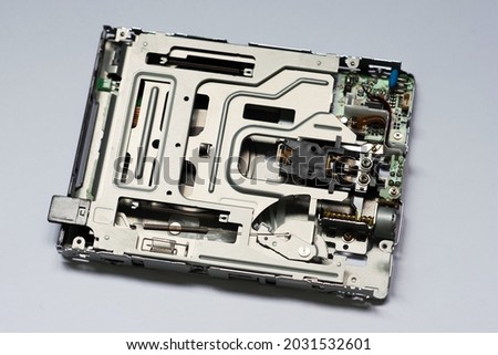 Disassembled floppy disk drive. Opened floppy reader. Drive, motor, gears and other mechanisms, microcircuits. Broken FDD 3.5 inch, repair of computer equipment