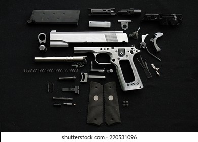 Disassembled handgun on black background, 