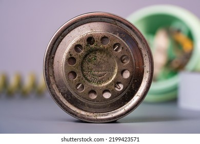 Disassembled Handset Of An Old Telephone. Metal Round Part Of A Speaker Or Microphone With Holes From Vintage Landline Phone On Blurred Gray Background. Broken Vintage Home Analog Telephone. Macro.