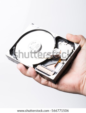 Disassembled hard disk drive in male hand on white background

