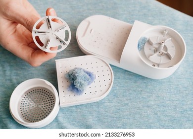 a disassembled machine for removing pellet and spools from clothes and fabric on blue fabric. A modern electronic device for updating old things.
