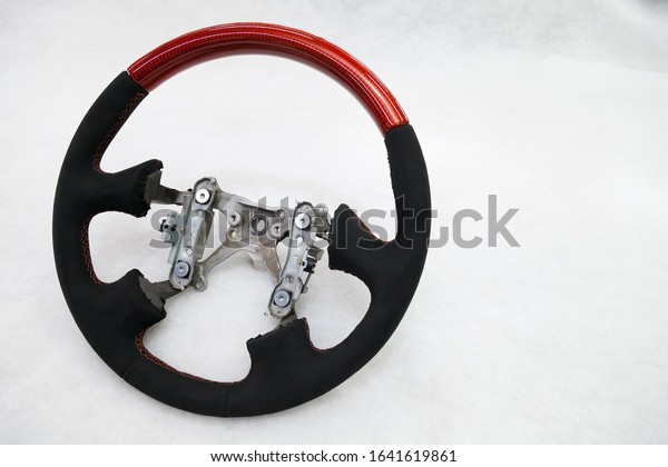 The disassembled\
steering part before installation of the equipment is a carbon\
alutex fibre orange wheel with soft genuine leather and tuning,\
stitched with a contrast\
thread.