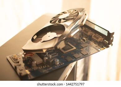 The Disassembled Video Card Of A Personal Desktop Computer With Two Coolers Lies On The Desktop PC System Unit.