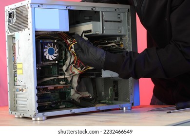 disassembly of an old desktop computer by a person on a table and a pink background
