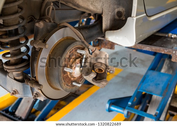 Disc brake of\
the car during the maintenance at auto service,closeup rear disc\
brake of the vehicle for\
repair.