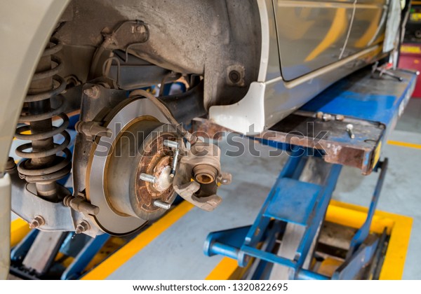 Disc brake of\
the car during the maintenance at auto service,closeup rear disc\
brake of the vehicle for\
repair.