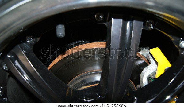 disc brake car /\
pads of disc brake with rust on disc in wheel car close up - Rusty\
steel on black chrome wheel\
