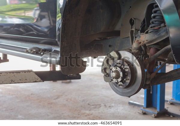 Disc brake on car, in process of new tire\
replacement,Car brake repairing in garage, automotive service\
station,mechanic changing a wheel and\
Tires