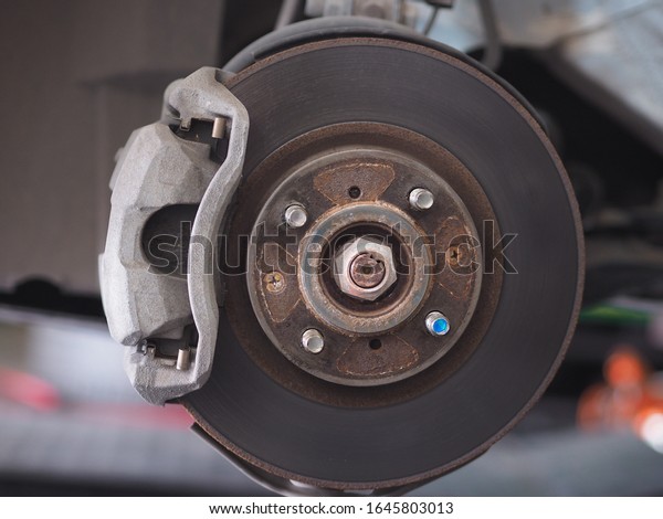 Disc\
brake rust of the vehicle for repair, in process of new tire\
replacement. Car brake repairing in car\
services