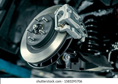 Disc brake of the vehicle for repair, in process of new tire replacement. Car brake repairing in garage.Suspension of car for maintenance brakes and shock absorber systems.Close up. - Shutterstock ID 1583295706