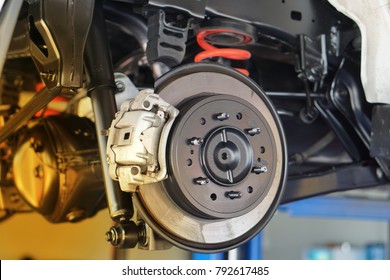 Disc brake of the vehicle for repair, in process of new tire replacement. Car brake repairing in garage.Close up. - Shutterstock ID 792617485