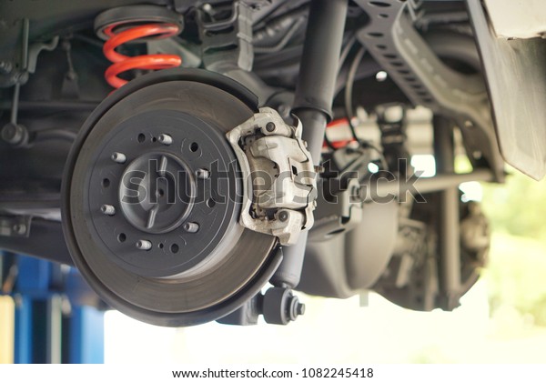 Disc brake of the vehicle for repair, in process of
new tire replacement. Car brake repairing in service car.Close
up.
