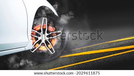 Disc brakes burn with high temperature and the smoke of racing cars on the racetrack at night