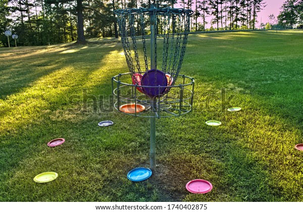 Disc golf\
basket with discs inside and\
outside.