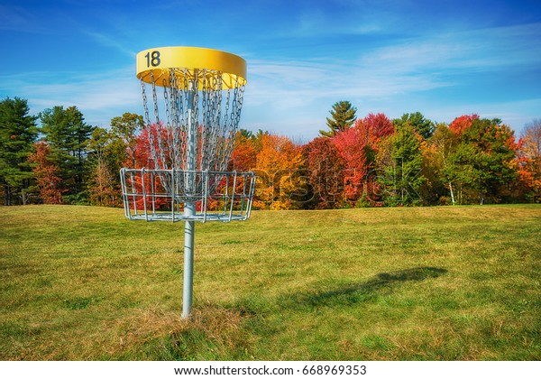 Disc golf hole basket in\
autumn park