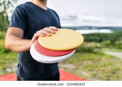 Disc golf player with equipment in park course. Man playing discgolf. Outdoor sport tournament. Summer landscape in Finland.