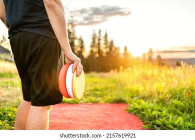 Disc golf in summer at sunset. Man with equipment in park course. Guy playing discgolf. Player in outdoor sport tournament. Landscape in Finland. - Shutterstock ID 2157619921