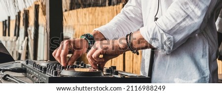 Disc jockey playing music for tourist people at the beach - Dj at music live event - Live event, music and fun concept - Entertainment and party concept - Focus on hands Сток-фото © 
