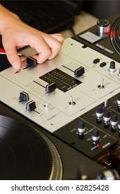 Disc Jockey Scratching Vinyl Records On Turntable Record Player. DJ Hand Mixing Two Tracks On Professional Sound Mixer Controller. Adjust Music Volume With Knob Regulators.Close Up,overhead Shot