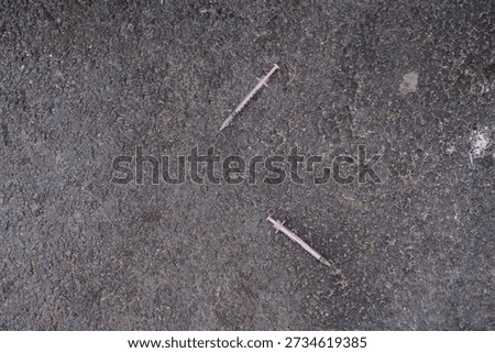 DISCARDED HYPODERMIC NEEDLES LYING ON STREET